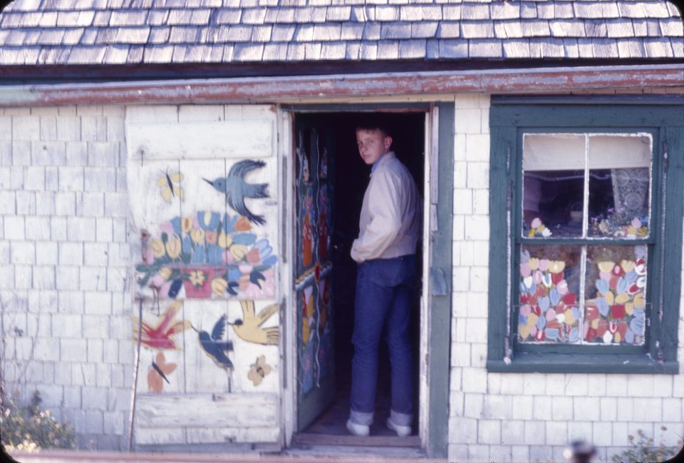 A boy stands inside Maud Lewis' home