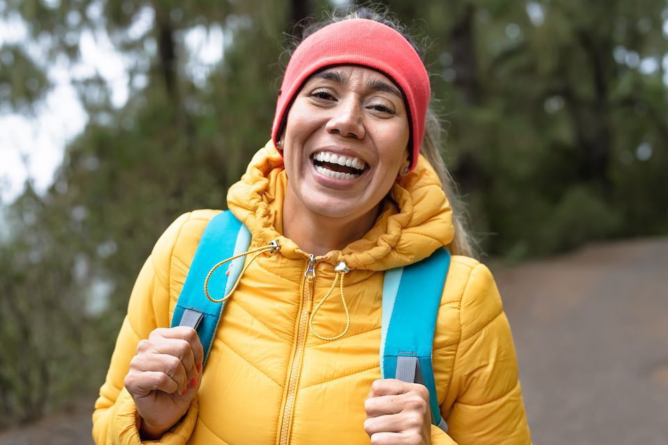 Happy woman having fun during trekking activities day in the woods