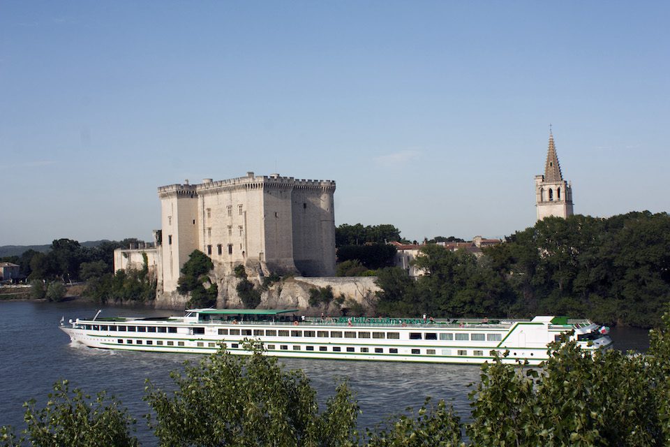 A river cruise ship makes its way down the Rhone River in France