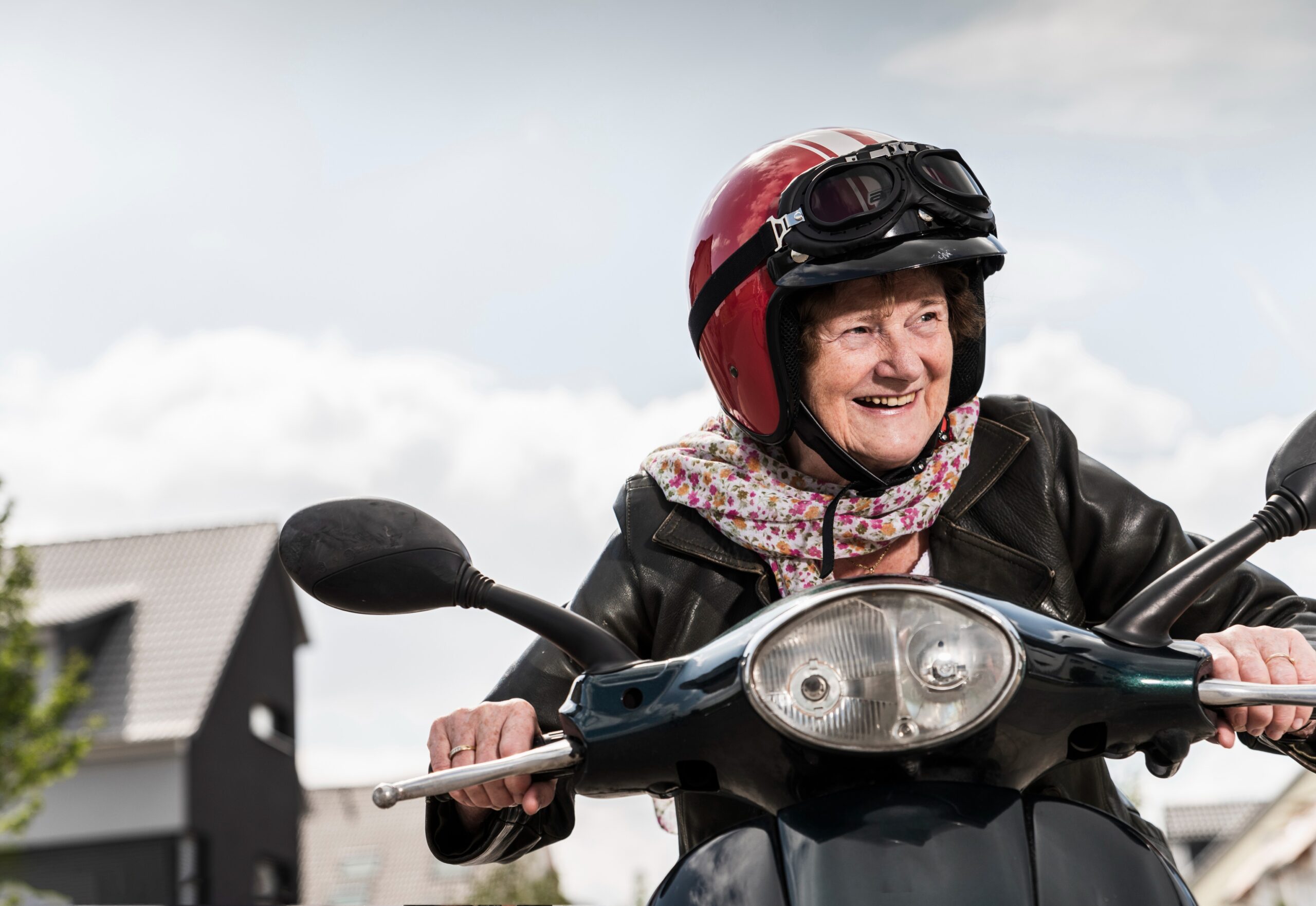 older woman smiling on a scooter