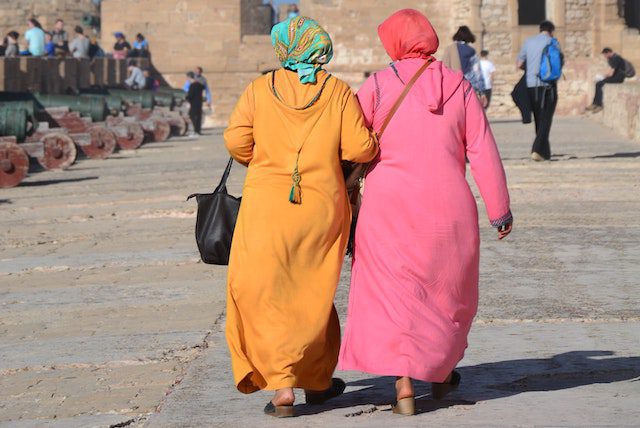 Two Moroccan women in colourful clothing walking through a street