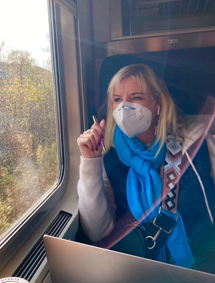 Travel hack the train! Make sure to wear comfortable headphones, like Carolyn sitting on this train through Europe