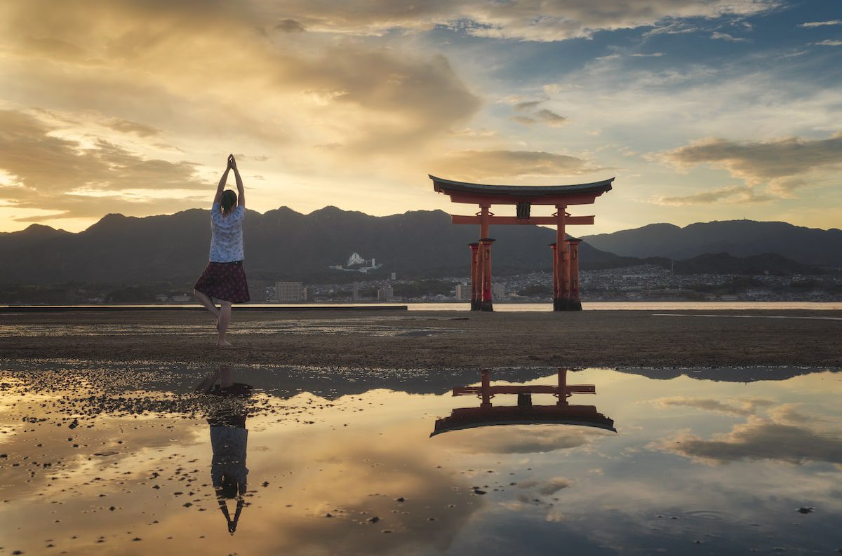 Woman enjoying the sunset on Itsukushima Island or Miyajima, Hiroshima, Japan