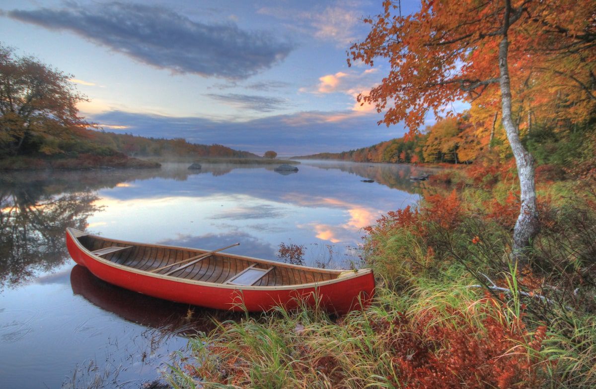 Sandra Phinney's red canoe sitting in the Tusket River in Nova Scotia