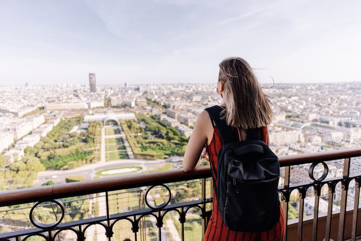 Tourist contemplating the city of Paris from the Eiffel tower