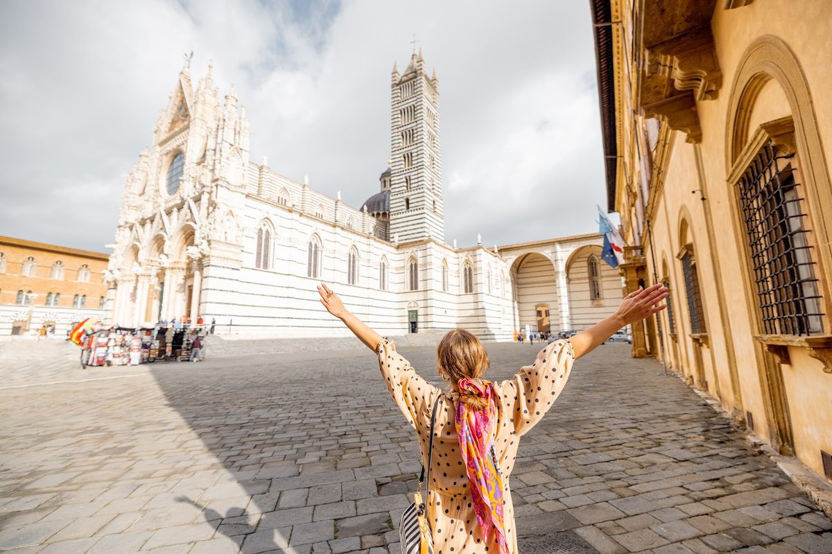 Woman enjoys beautiful architecture of Siena cathedral in Tuscany