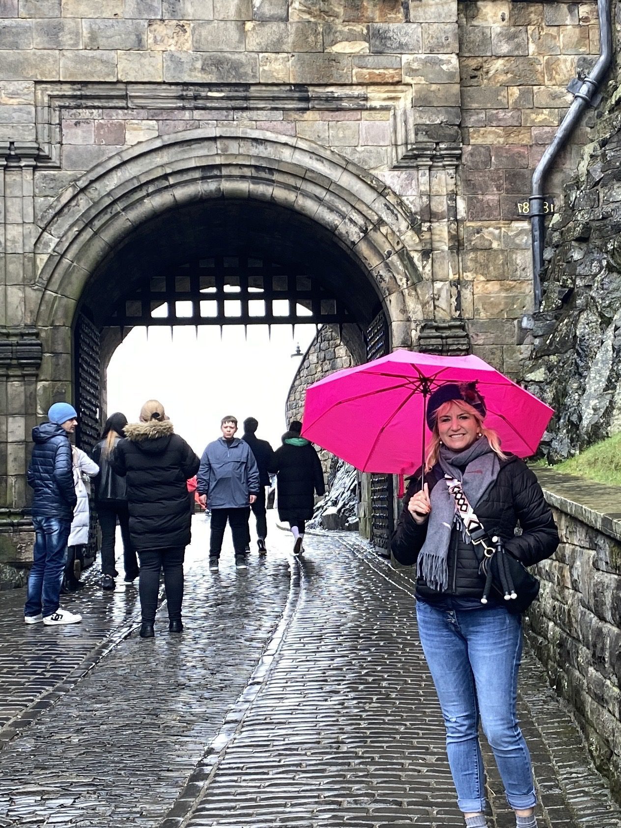 Edinburgh Castle in the rain with pink umbrella