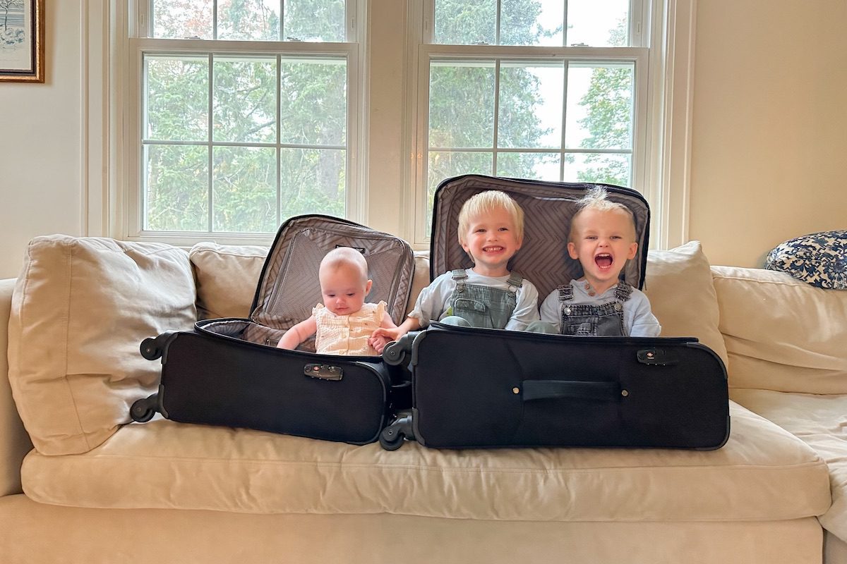 Travel with grandkids sitting in open luggage