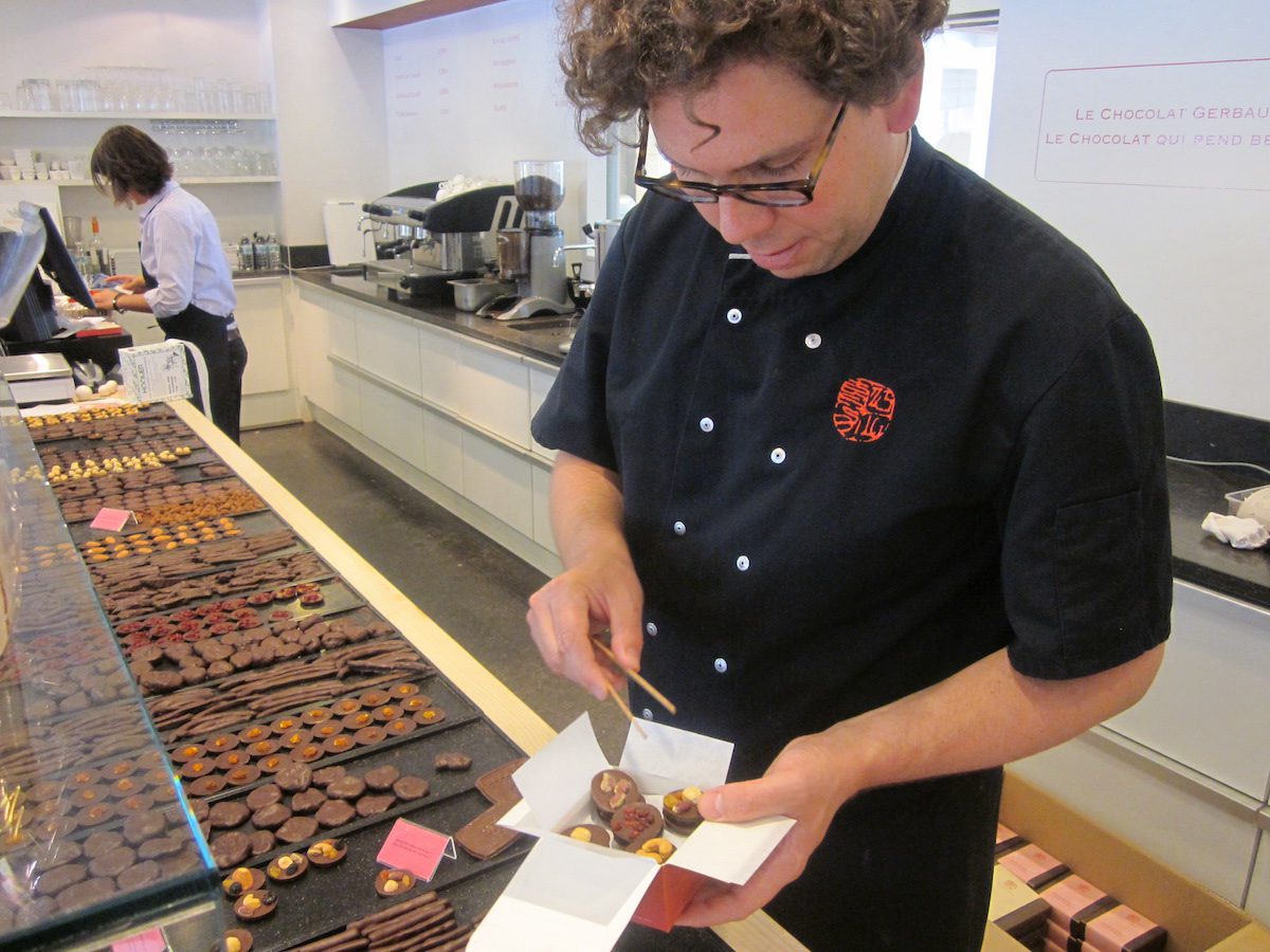 A man packing a box of Belgian chocolates at Laurent Gerbaud’s chocolate shop