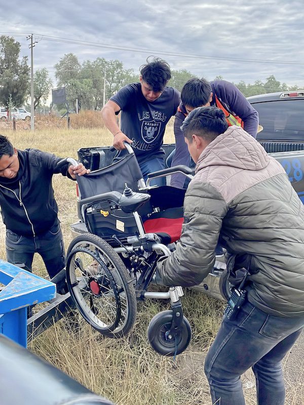 Ground staff prepare to help a woman ride a hot air balloon in a wheelchair