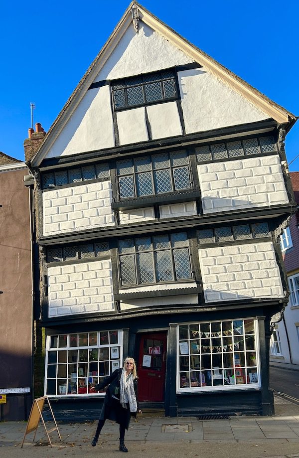 Carolyn Ray standing in front of the Crooked House in Canterbury, England