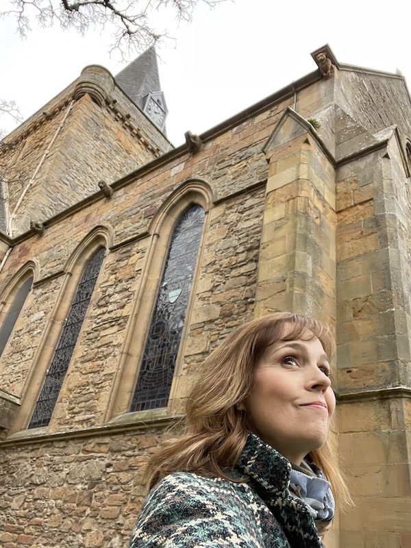 Cynthia Dale in front of the cathedral in Dornoch, Scotland