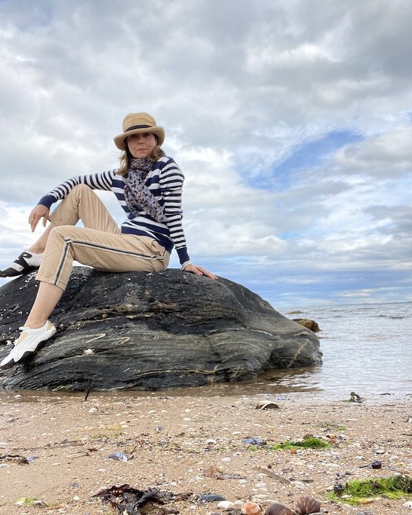 Cynthia Dale sits on a rock on a beach in Dornoch, Scotland