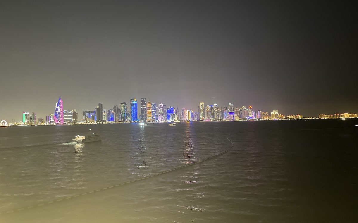 The Doha city skyline illuminates the waterfront at night time