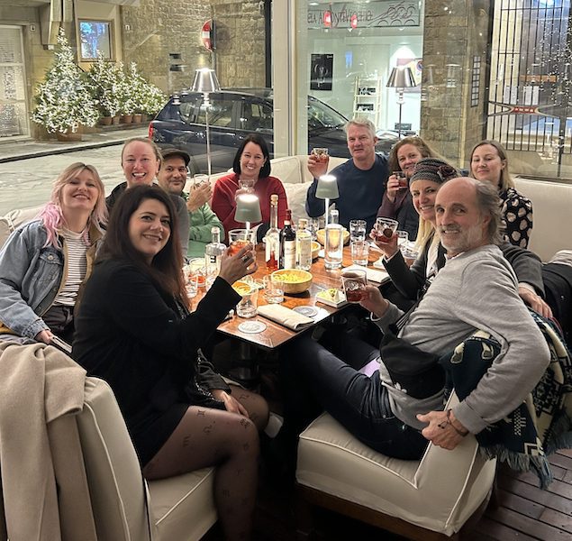 A group of people enjoy traditional Florentine foods and drinks on a culinary tour in Florence.