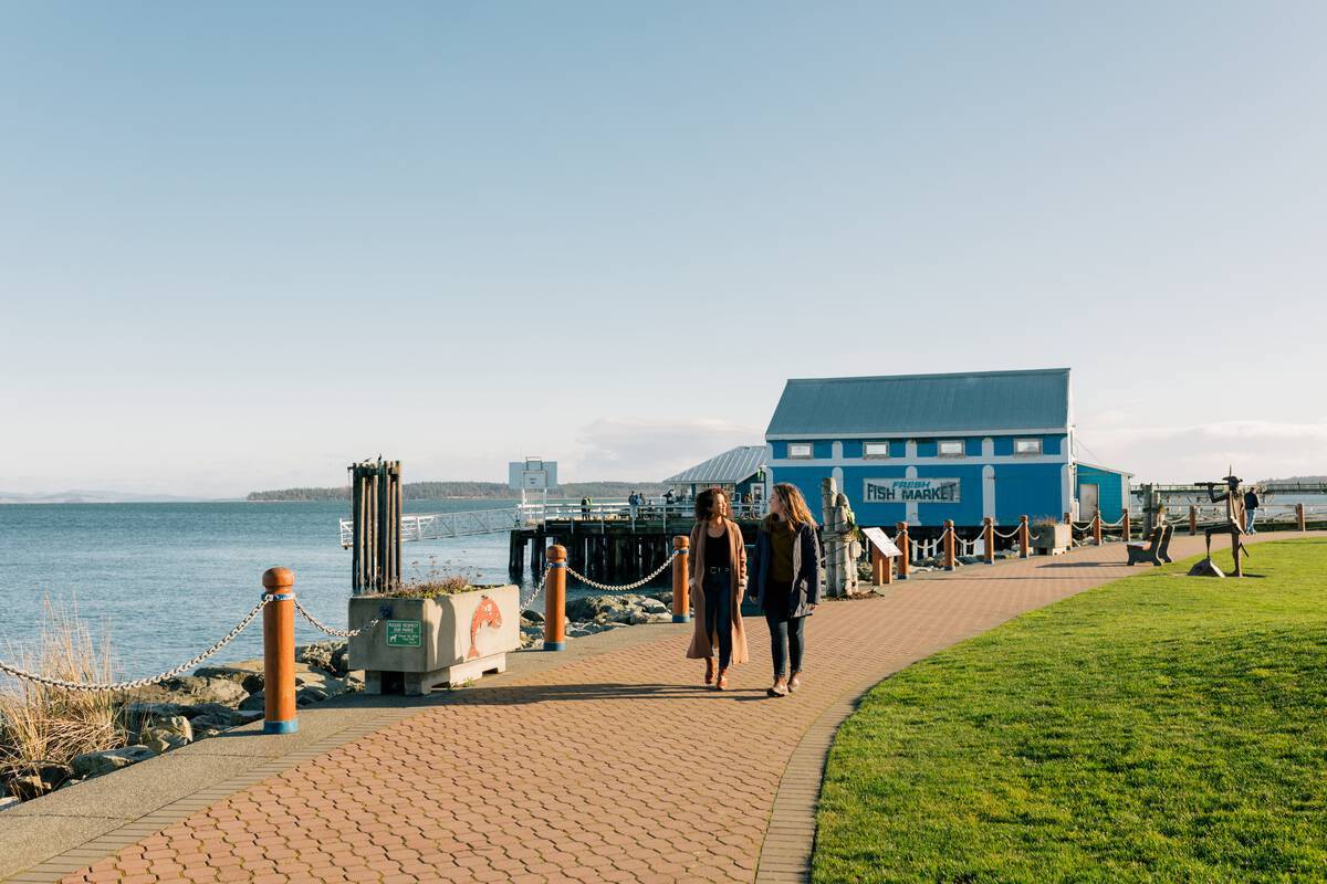 People walking along the boardwalk in one of Canada's hidden gems Sidney-by-the-Sea British Columbia