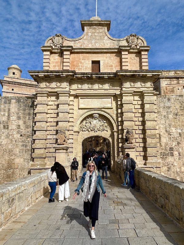 Carolyn Ray in front of the medieval gate in Mdina, Malta