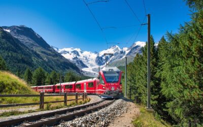 Famous Bernina tourist train passing under the glaciers of the Swiss Alps