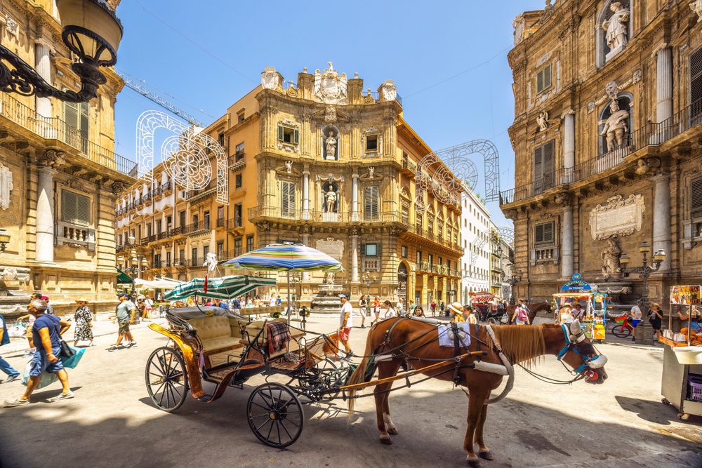 busy street in Palermo Sicily Italy with horse drawn carriage people
