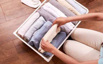 woman folding clothes in bin and decluttering for travel