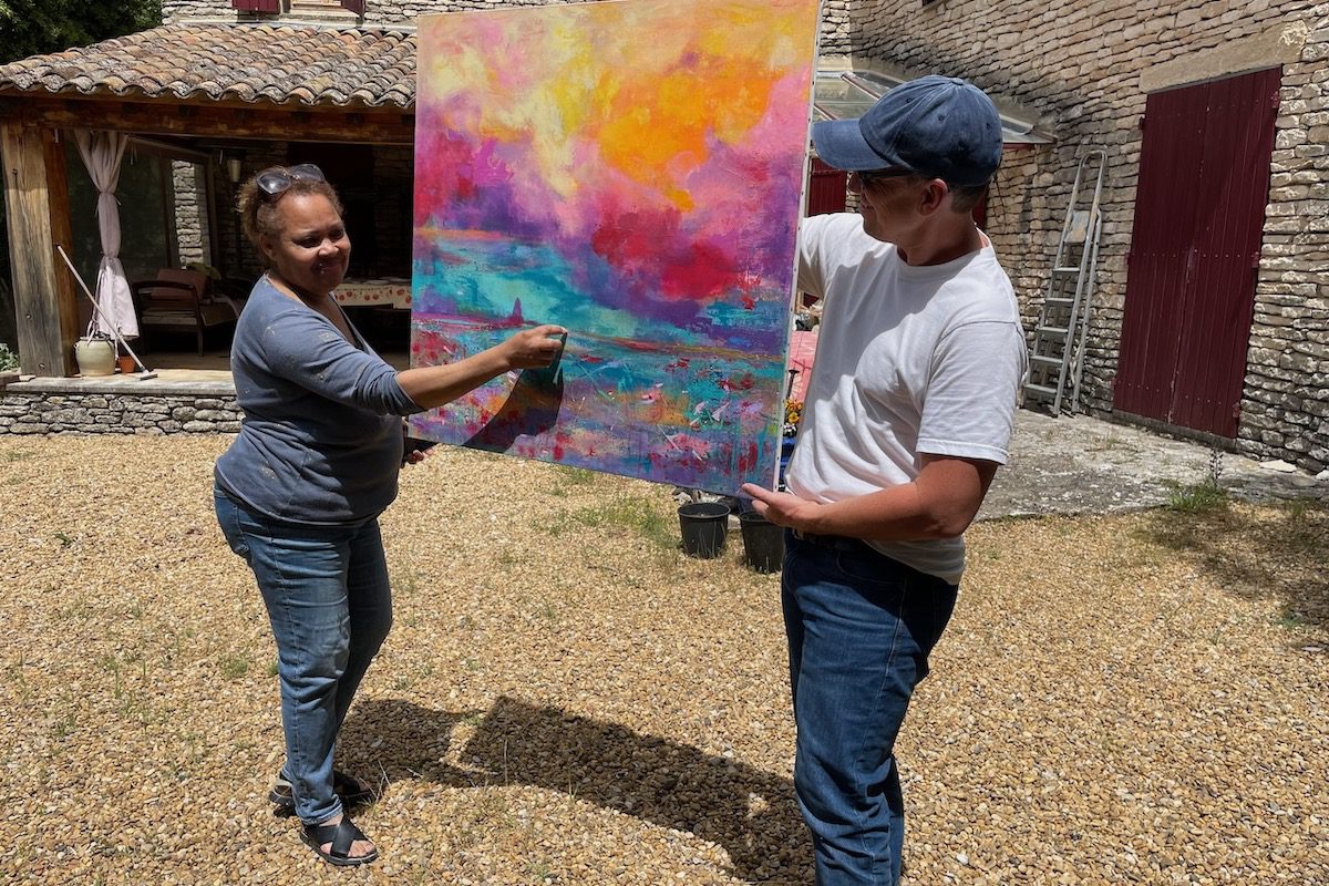 Local artist Janice Jacquet unveils one of her paintings ahead of her upcoming gallery opening