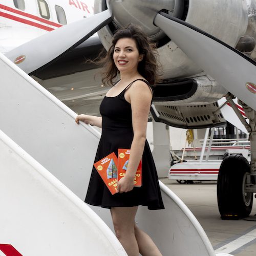 Nikki Vargas getting onto an airplane holding a copy of her book, Call You When I Land