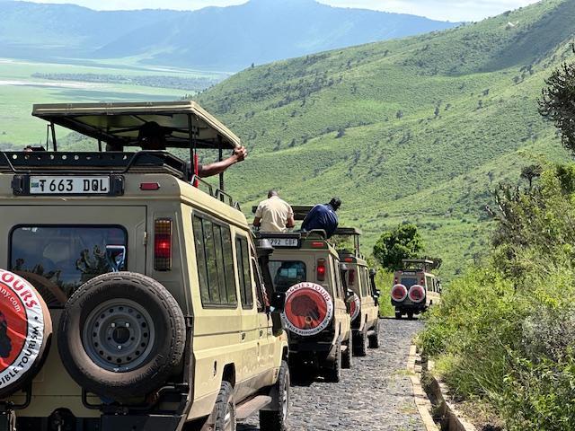 A convey of vehicles from Maggie's Tour Company drive through Tanzania