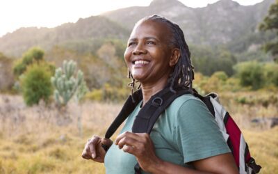 Portrait of active senior woman with backpack going for a hike in countryside