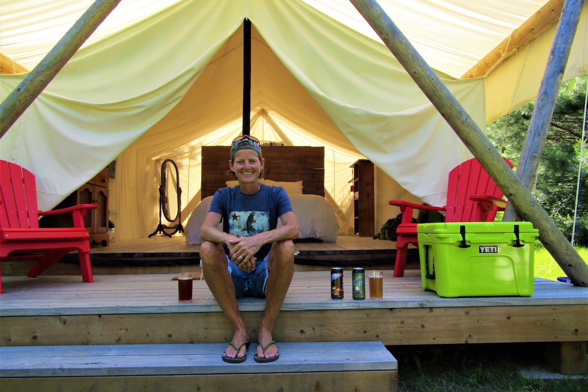 Jules Torti enjoys local craft beer in front of a glamping tent in Simcoe, Ontario