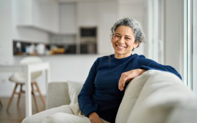 Happy middle aged woman sitting on comfy sofa in living room on a home exchange