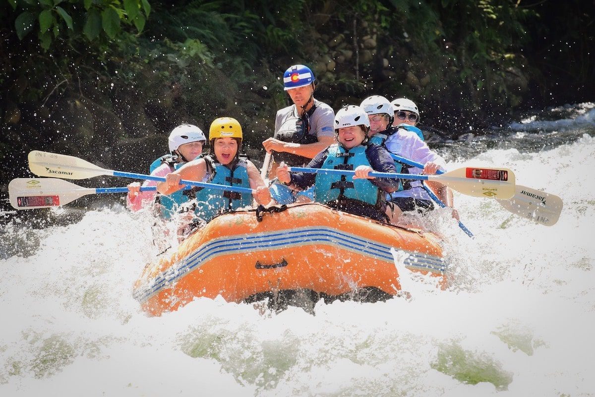 A group of women white-water rafting on a Sisterhood Travels group trip.