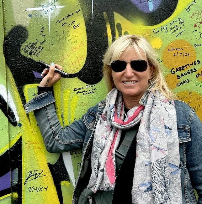 Carolyn signing her message on the Peace Wall