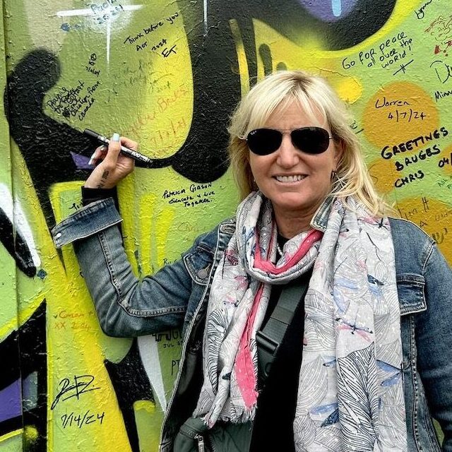 Carolyn signing her message on the Peace Wall