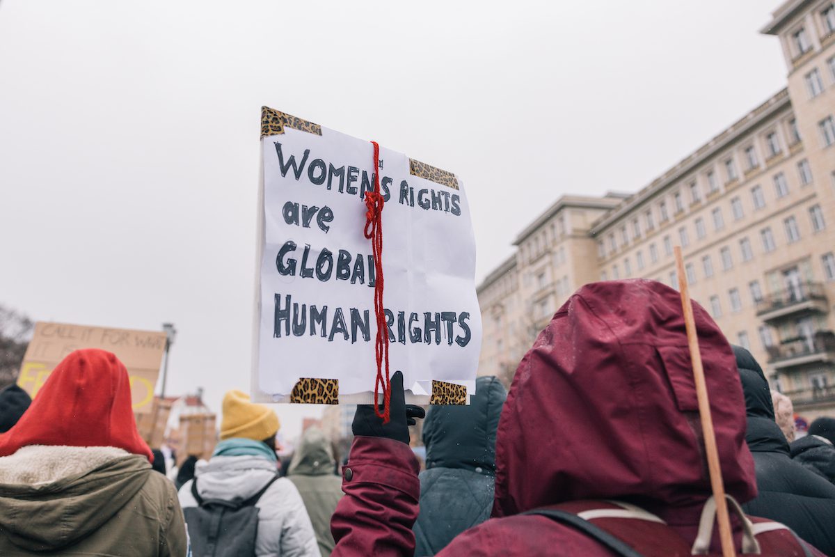 A woman holding a sign at a protest that says "women's rights are global human rights"