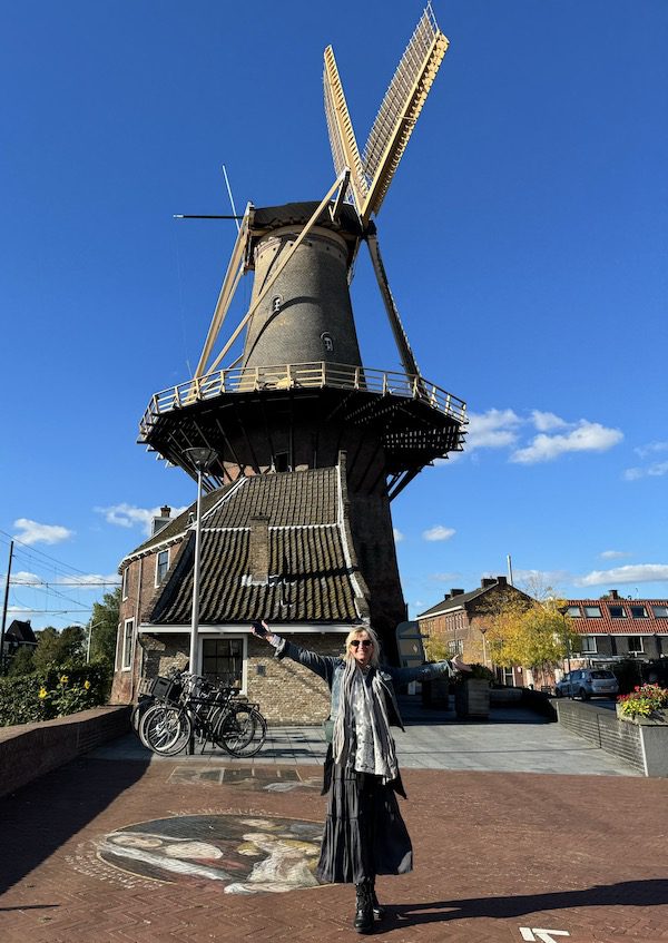 Carolyn stands in front of a windmill in Delft, Netherlands