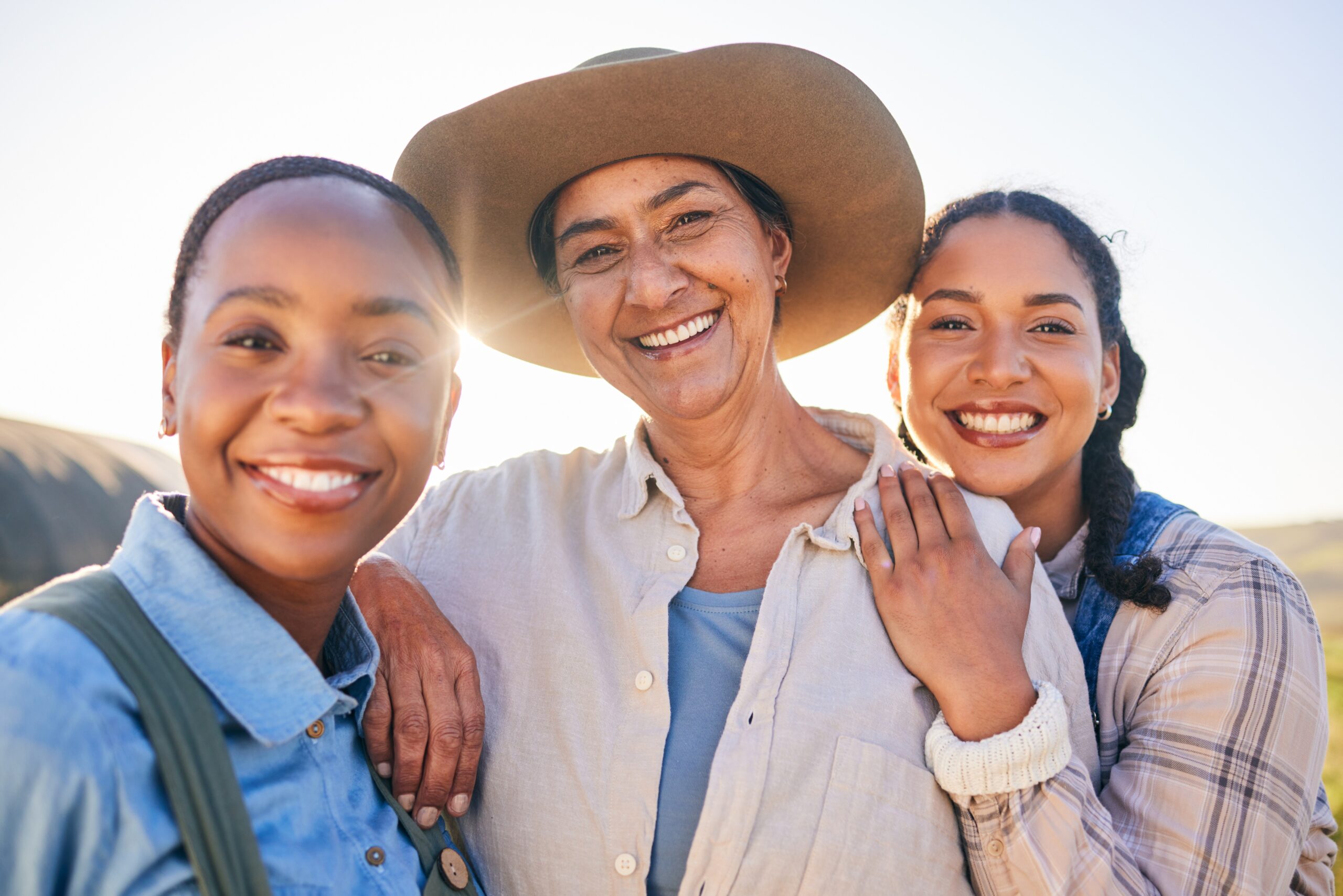 Three women smiling in the countryside