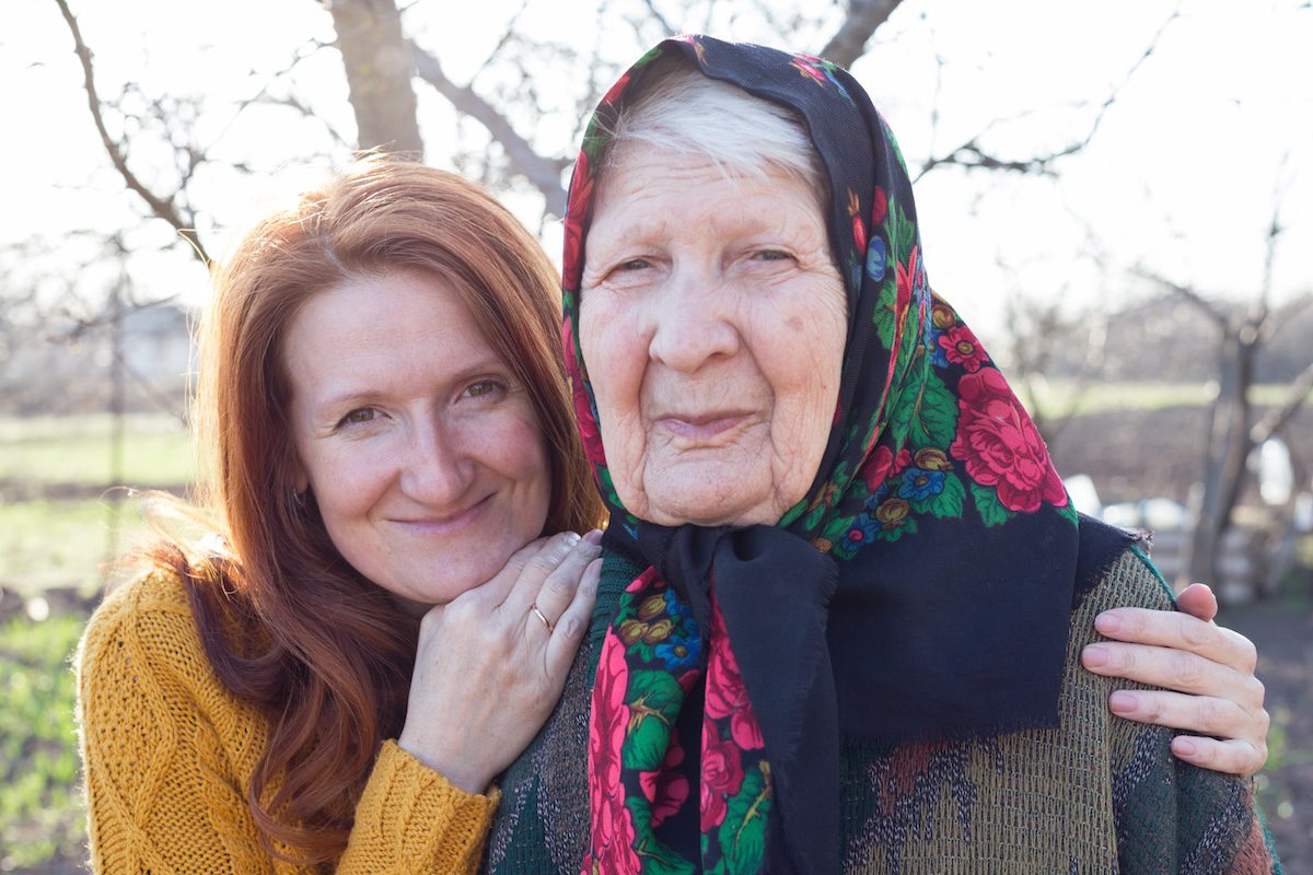 Smiling senior woman and granddaughter exploring ancestry travel