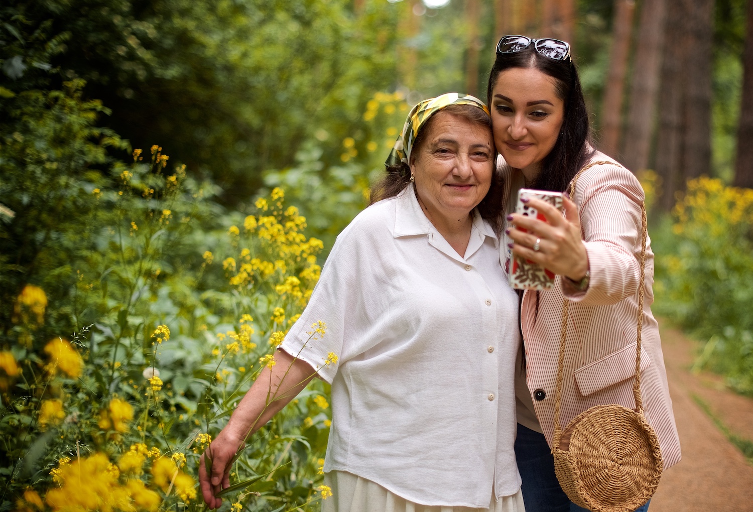 Candid turkish family of mother and daughter making selfie together in the summer park