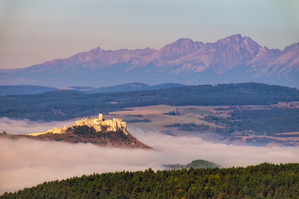 Scenic view of Spis castle ruins and High Tatras mountain range before sunrise, Slovakia