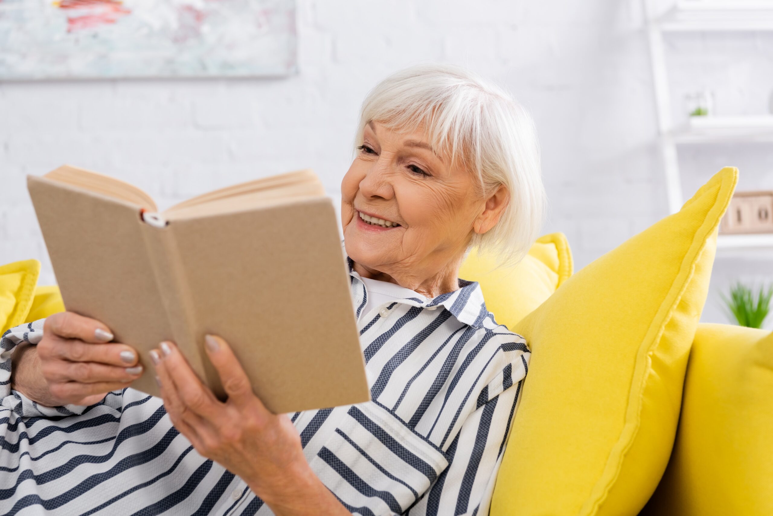 older woman reading books to inspire travel 2026